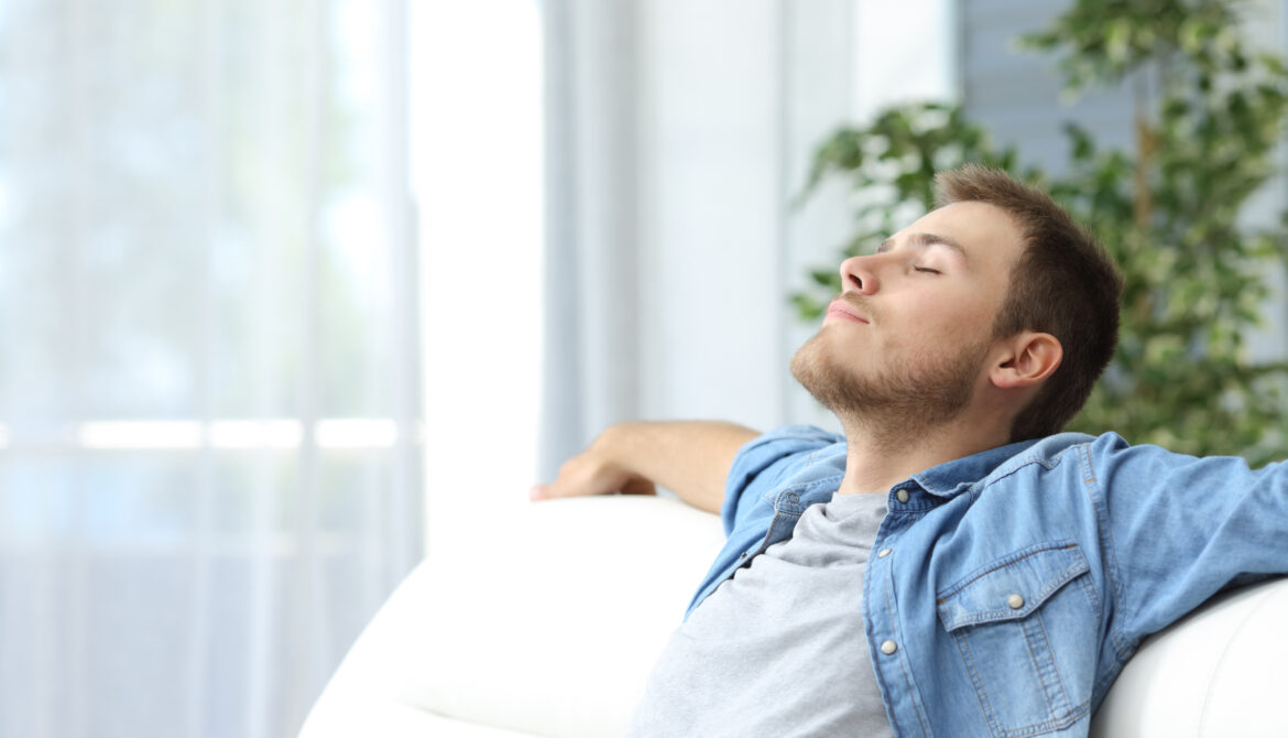 man relaxing on the sofa enjoying fresh air in his home