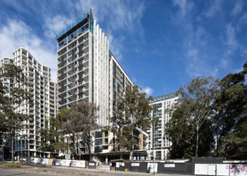 External view of the Nature Macquarie Park development, image Showa the a multi story residential tower against a bright blue sky