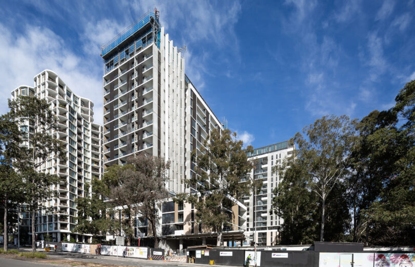 External view of the Nature Macquarie Park development, image Showa the a multi story residential tower against a bright blue sky