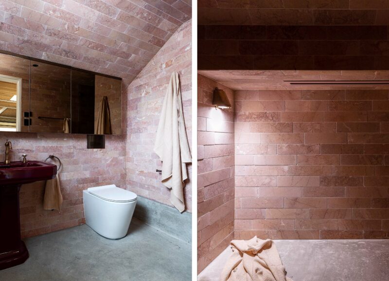 The loft bathroom at Alexander House features pink marble tiles, concrete flooring, a vintage basin and Expella's Linear Slot Grille and Milu Odourless in-wall toilet